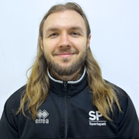 Head shot of James personal trainer against white wall, smiling at camera.