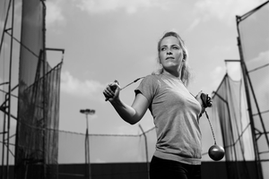 Black and white image of girl with hammer in hammer arena.