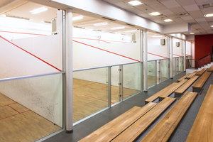 Row of empty glass backed squash courts.