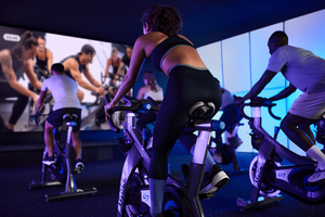 indoor cycling class people cycling watching a screen
