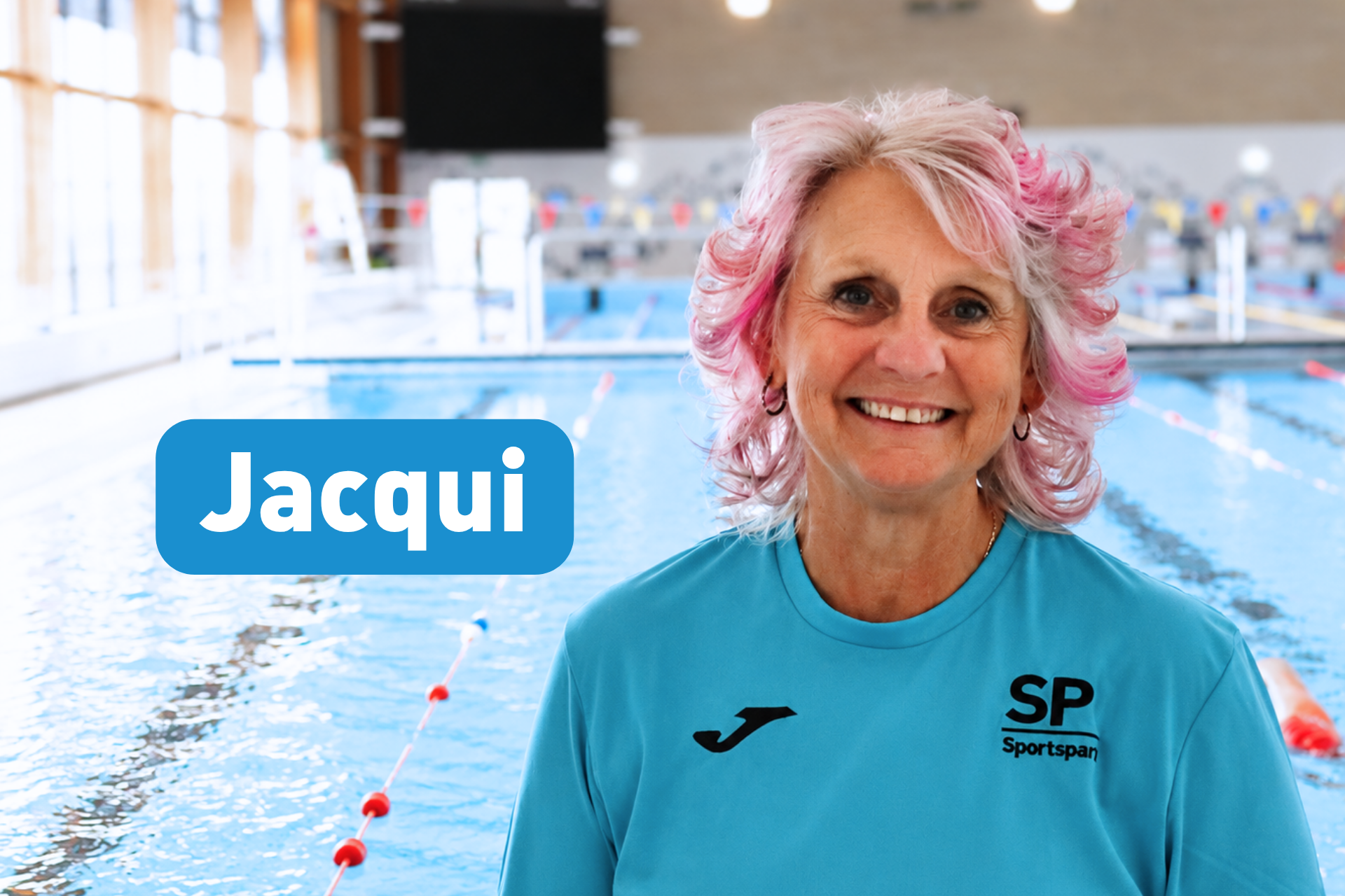 Headshot of Jacqui smiling at camera standing in front of 50m pool.