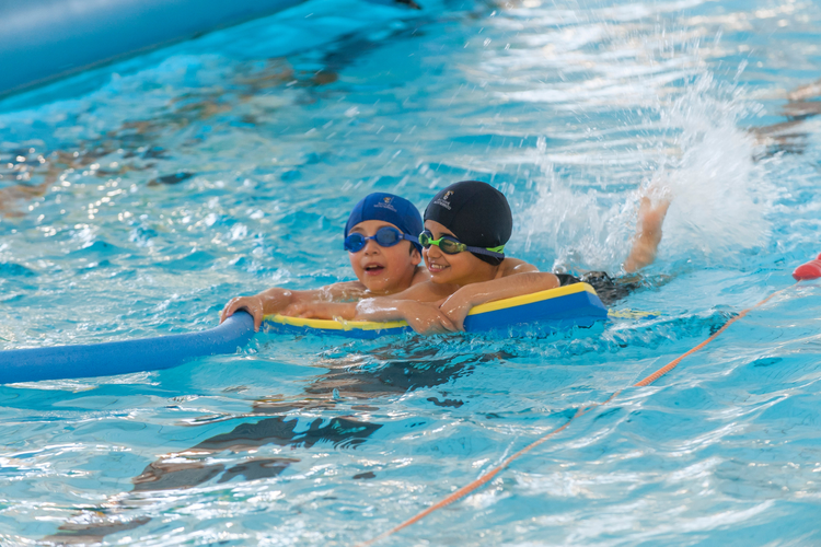 Children swimming on pool float.