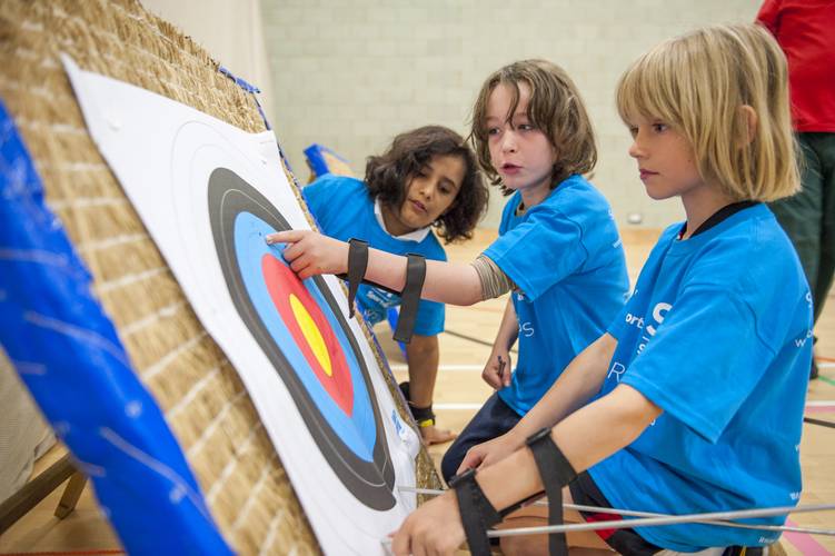 children looking at archery target