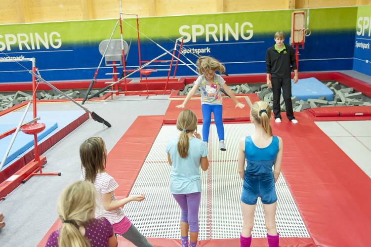 young girl jumping on trampoline in gymnastics centre