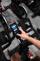 person using screen on spin bike in cycle studio