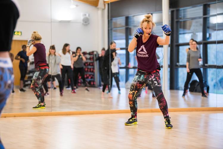 group exercise class with instructor punching