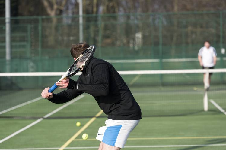 tennis player outdoors hitting ball