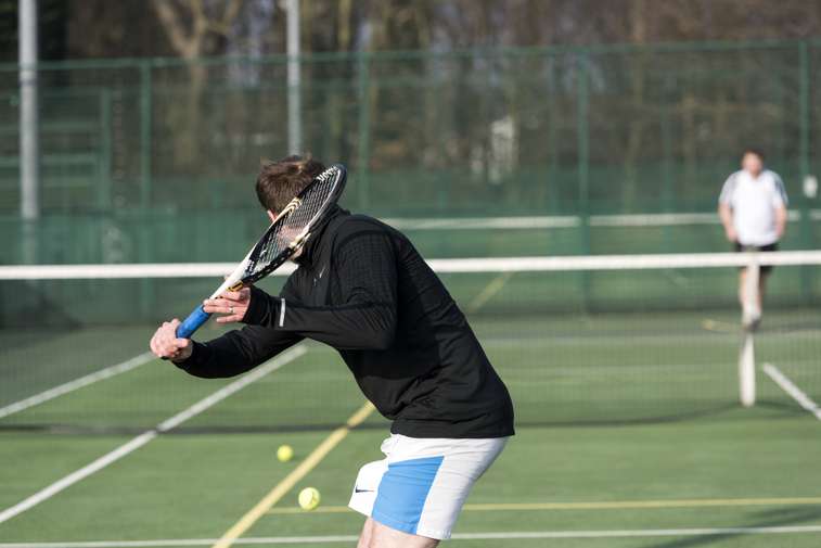 tennis player outdoors hitting ball