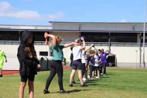 line of children preparing to throw a javelin.