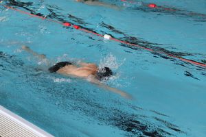 Man swimming a length of swimming pool.