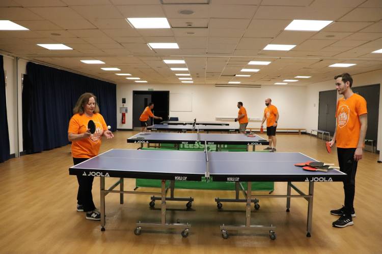 Man and woman playing table tennis in indoor studio.
