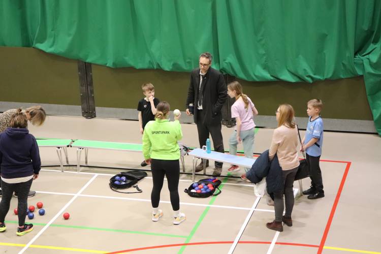 parents and children on boccia court in sports hall listening to instructor