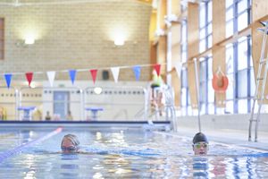 two people swimming in the deep end of the pool