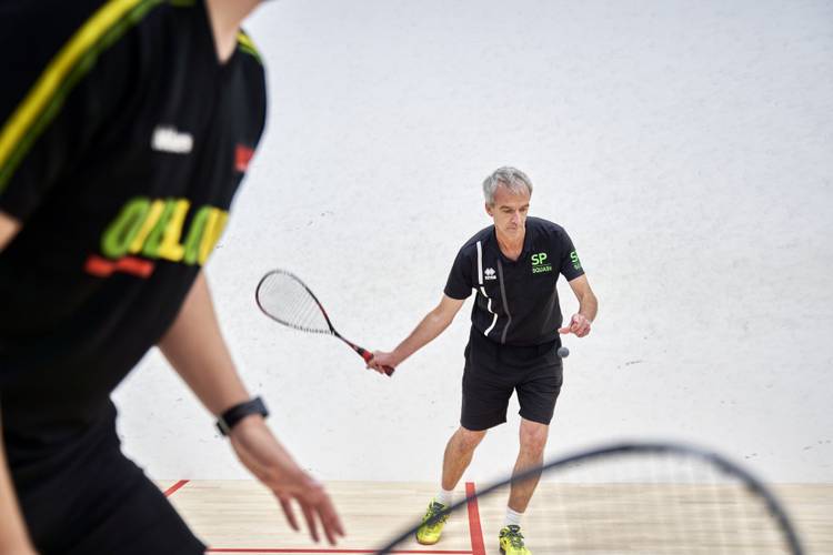 a squash coach serving the ball