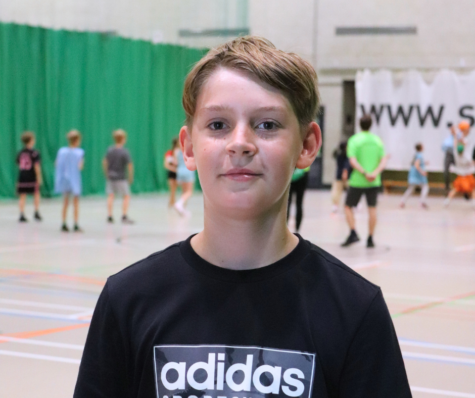 Boy smiling at camera in sports hall