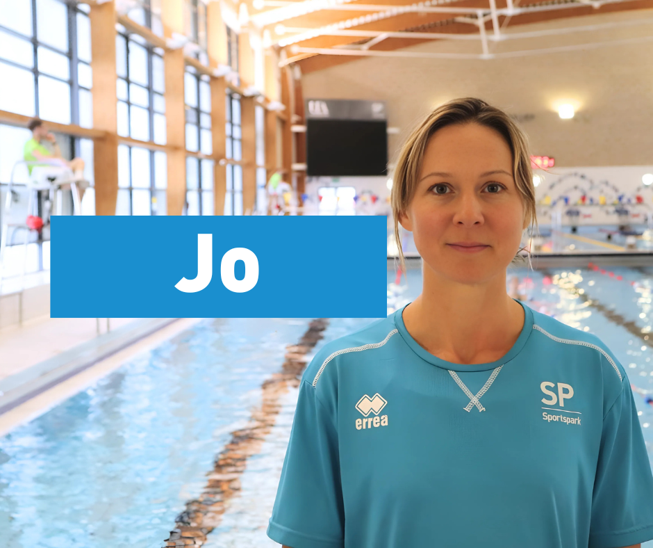 Female swim teacher in front of pool with name tag Jo